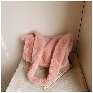 Detailopname van een zachte roze schoudertas van imitatiebont met pluche textuur