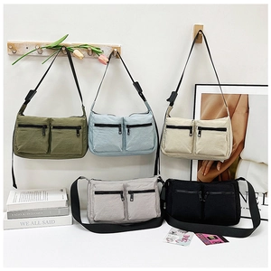 Detail shot of multi-pocket nylon crossbody bags in olive, blue, beige, grey and black