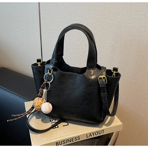 Détails du sac seau vintage en cuir noir avec breloques baseball et boucles dorées