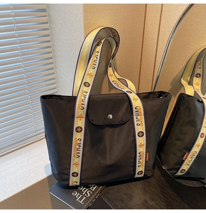 Detail of black nylon tote bag with colorful woven SICHUAO straps and snap closure