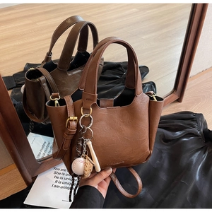 Détail du sac seau rétro marron avec un pendentif créatif en forme de gant de baseball