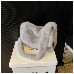 Detail van zachte lichtgrijze faux fur shopper met pluche schouderband en houten hanger