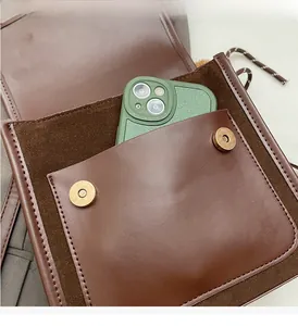 Vue macro de l'intérieur du sac en cuir brun montrant une poche durable et l'espace téléphone