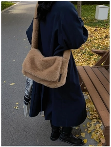Bruine crossbodytas van imitatiebont gedragen door een model in een herfstige omgeving