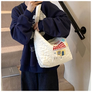Detail der weißen Stepptasche mit süßen Cartoon-Haus- und Gespenster-Stickereien