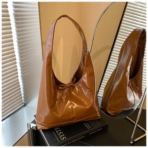 Macro view of a brown glossy tote bag with a bow knot detail on an art book