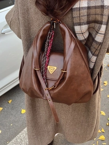 Vintage brown leather backpack with pleated design and tricolor woven rope detail