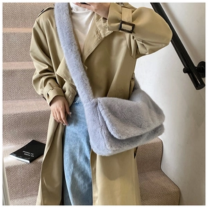 Detail van een lavendelkleurige pluche crossbodytas gecombineerd met een klassieke kaki trenchcoat