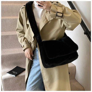 Detail van de zachte zwarte pluche crossbodytas gecombineerd met een trenchcoat