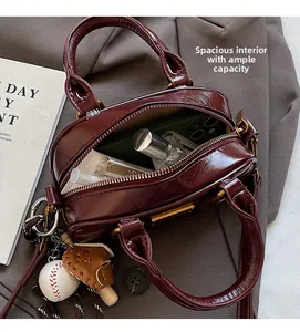 Interior view of spacious burgundy bowling bag with phone, perfume, and charms