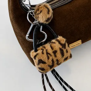 Close-up of leopard print plush charm attached to a dark brown frosted dumpling bag