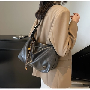 Detailed view of dark grey hobo bag featuring woven rope accent and gold brand logo