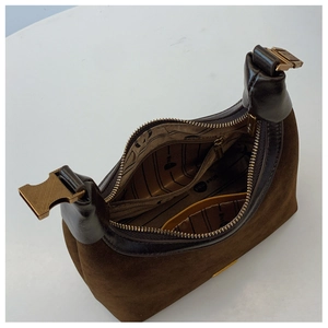 Detail view of the brown suede handbag showing striped lining and inner pocket