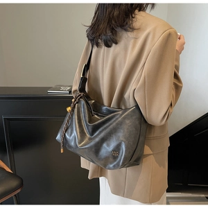 Deep grey leather tote bag featuring slouchy design and metal logo detail