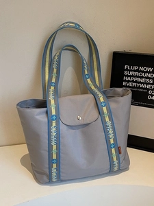 Minimalist grey nylon tote bag with colorful embroidered straps for daily commute