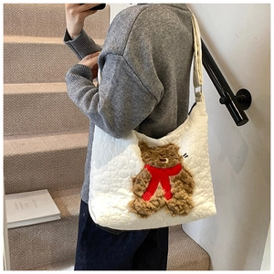 Detail der weißen Stepp-Tasche mit einem süßen 3D-Teddybären und einem roten Schal