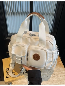 Waterproof off-white nylon handbag with multiple pockets and adjustable shoulder strap