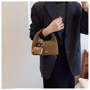 Detail of coffee brown matte dumpling bag with leopard charm and geometric silk scarf