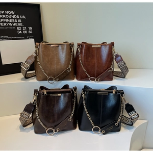 Détail de quatre sacs seaux rétro en cuir ciré avec des bandoulières tressées ethniques