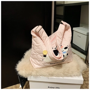 Detail der rosa gesteppten Tasche mit Herznaht, Welpenstickerei und großem gelbem Knopf