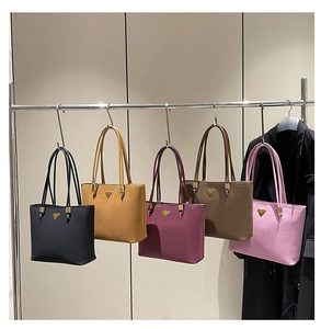 Detail view of stylish tote bags in five colors with slim straps and metal accents