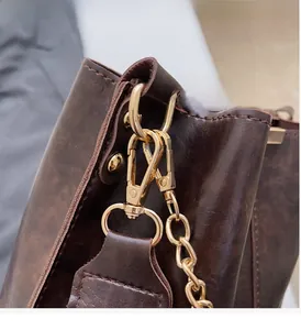 Détails de la boucle dorée et du cuir marron vintage sur ce sac seau élégant