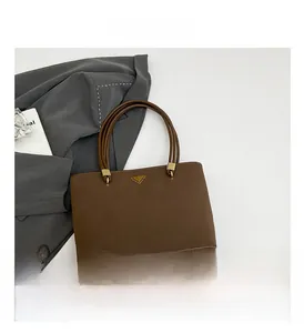 Close-up of caramel brown leather tote bag with gold metal hardware and slim handles