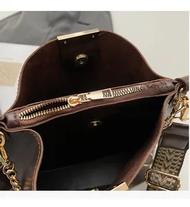 Détail du sac seau en cuir marron montrant la poche intérieure et la bandoulière