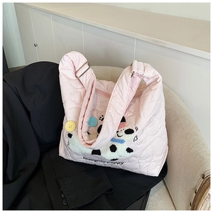 Detail der rosa gesteppten Tasche mit Herzmuster und besticktem Welpen auf dem Sofa