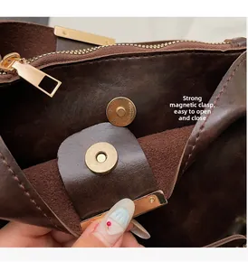 Détail du fermoir magnétique et fermeture éclair dorée sur sac en cuir marron