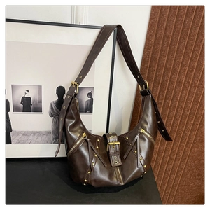 Close-up of vintage dark brown leather shoulder bag with gold rivets and metallic hardware