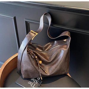 Detailed shot of dark brown hobo tote with vintage texture and gold hardware accents