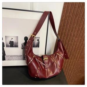 Macro shot of dark burgundy hobo bag with gold studs and vintage punk leather fringe