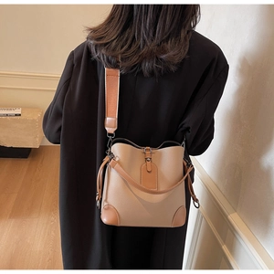 Detail of khaki leather bucket bag featuring drawstring and textured pebbled finish