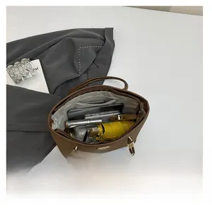 Macro shot showing large capacity interior of brown leather tote bag with various items
