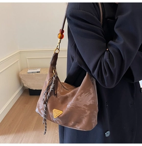Detail showing amber bead strap and coffee pleated nylon shoulder bag texture