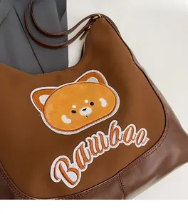 Détail du sac cabas marron avec écusson ours mignon et broderie Bamboa
