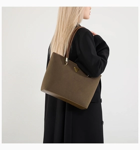 Detail of large olive green tote bag with premium leather handles and golden metal logo