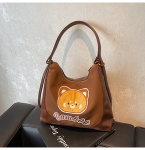 Détail de la broderie d'ours et du texte Bamboo sur ce sac à bandoulière marron décontracté