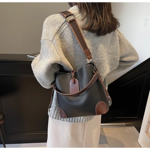 Fashionable contrast color bucket bag with lychee texture shown on a model's back