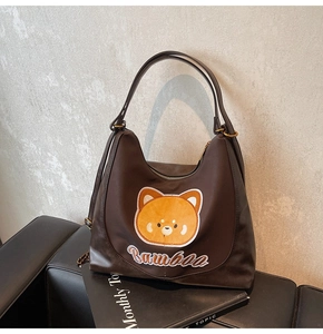 Détail du sac à bandoulière marron avec broderie d'ours et double bandoulière