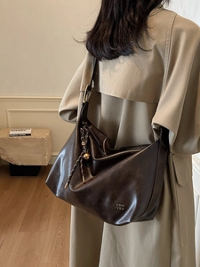 Retro deep brown large capacity leather tote bag with metallic charm on modern background