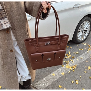 Vue détaillée du sac cabas en similicuir marron avec trois poches à boucles argentées