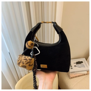 Detailed close-up of a black matte hobo bag with gold logo and leopard print charm
