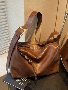Classic dark brown leather hobo bag with wide shoulder strap and gold buckle