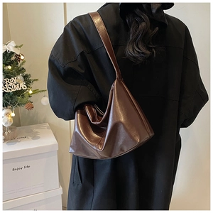 Retro dark brown leather tote bag styled with a long black winter coat for women