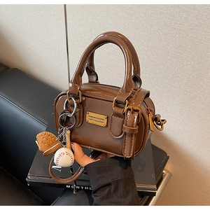 Detail of vintage brown mini Boston bag with baseball charm and gold hardware