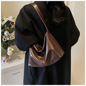 Detail of vintage brown leather tote bag showing glossy texture and spacious slouchy design