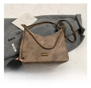 Detail of vintage brown tote with gold chain strap and fashion logo on wool coat