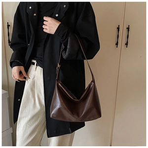 Detail view of smooth dark brown leather tote bag with metallic adjustable strap buckle